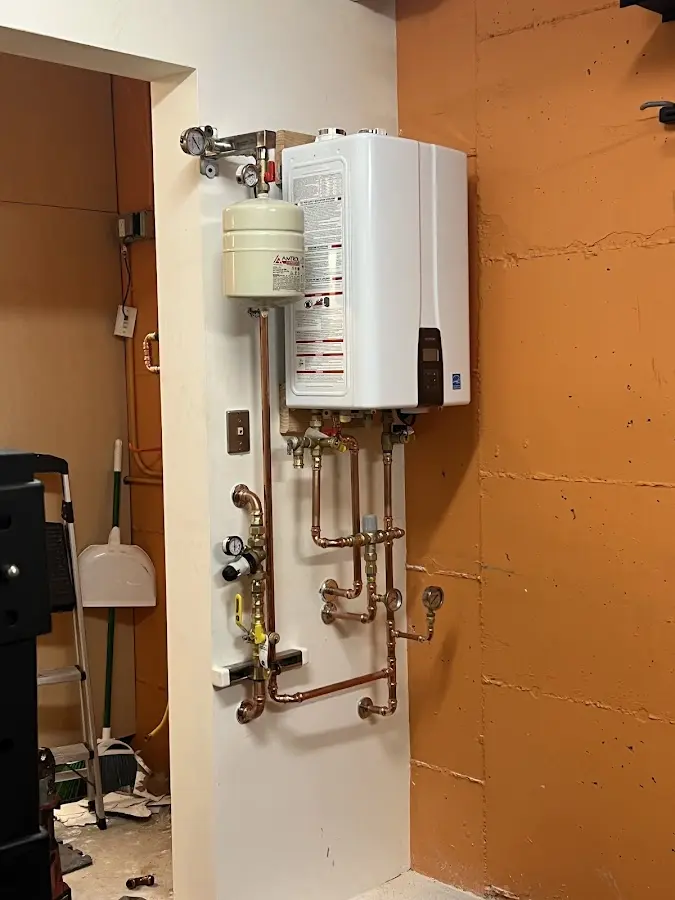 Plumbing technician inspecting water heater connections in Chesterland
